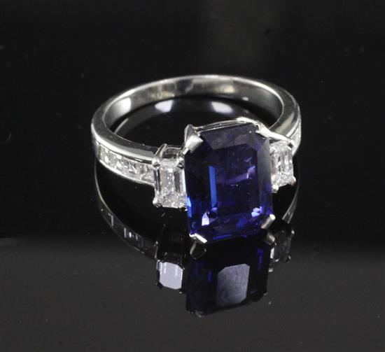 An attractive platinum, three stone sapphire and diamond ring with diamond set shoulders, size O.